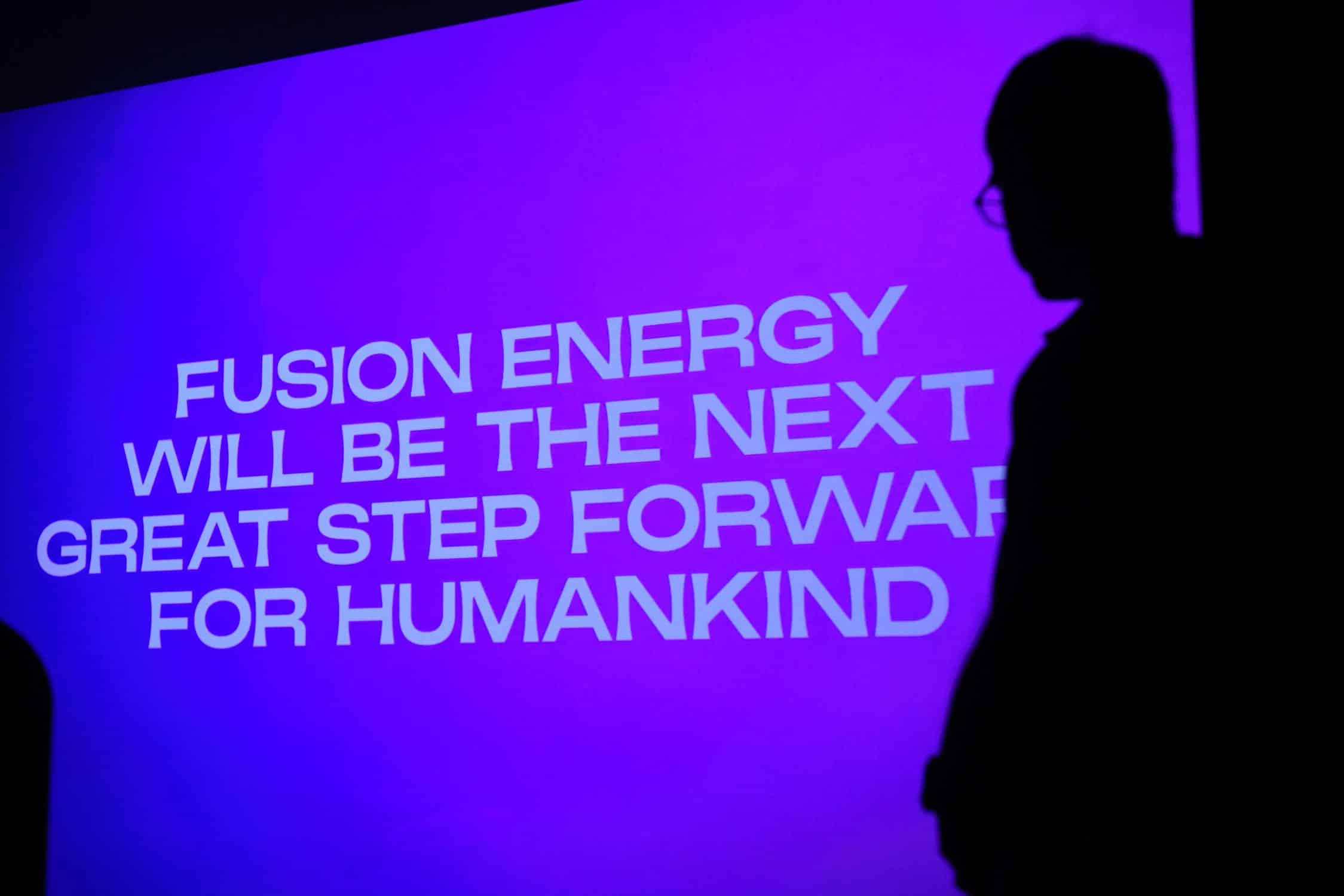 Silhouette of a person in front of a screen displaying: "Fusion energy will be the next great step for humankind."